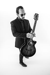 Oli in Suit holding guitar