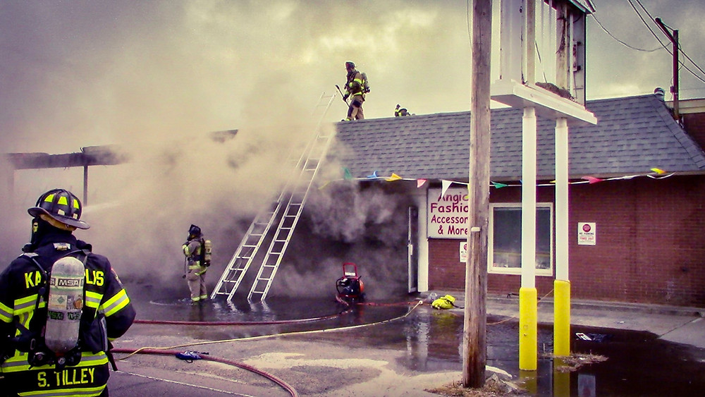 Firefighters work at a fire in a strip mall.