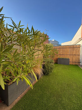 Terrasse végétalisée à Saint-Ouen : laurier rose, brise-vue bambou et jardinière d'aromatiques