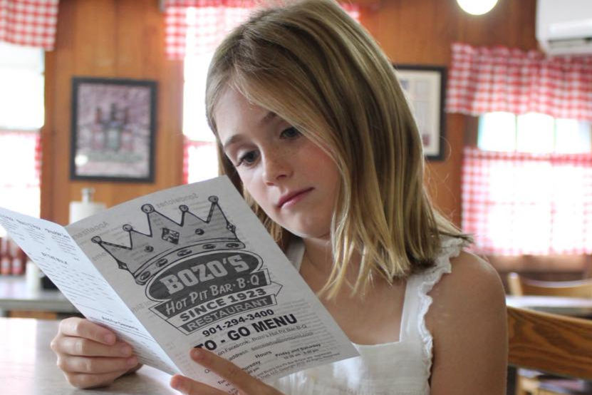 Girl reading Bozo's BBQ to-go menu