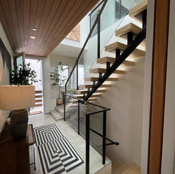 Entry with glass railing system and black posts.