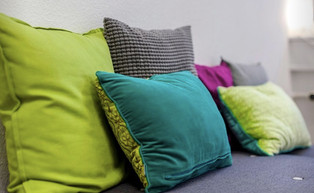Farbige Kissen auf Sofa: Grün, Grau, Pink