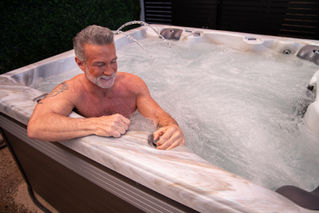 Man using control valve in hot tub