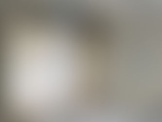 Pièce en rénovation avec câbles bleus pendants du plafond, échelle pliante contre un mur blanc. Sol protégé par bâches et adhésif.