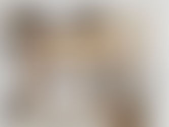 Vue aérienne d'une chambre minimaliste avec lit beige, fauteuil, tapis gris et rideaux crème. Ambiance paisible et lumineuse.