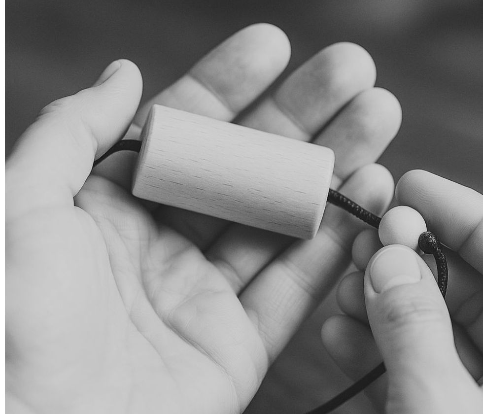 Mans sostenint un pèndol hebreu, eina de neteja i ordre energètic.