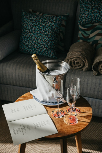 Fotografía de una botella de champagne metida en un cubo de metal con hielo al lado de tres copas de champagne en Cala San Miguel Ibiza Resort
