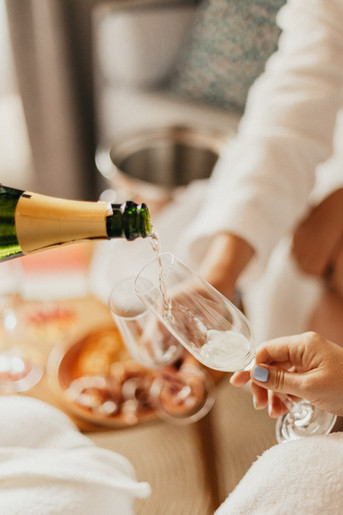 Dos manos sujetando dos copas mientras sirven champagne en una de las habitaciones del Resort Cala San Miguel Ibiza