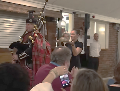 Bagpiper Julia Read piping the haggis at Burns night in Slough Hockey club