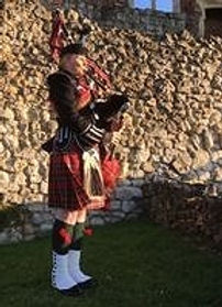 Bagpiper Julia Read playing at Farnham Castle in Surrey, dressed in full military number 1 uniform, royal stewart