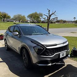 Silver Kia Sportage SUV on a sunny driveway