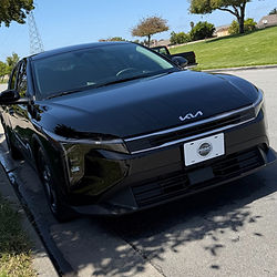 Shiny black Kia car parked on a street