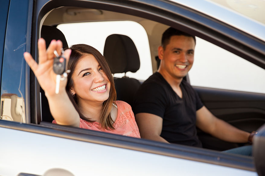 Couple in car, holding new key fob.