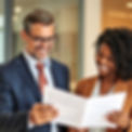 a business man and a black woman reading a business report both smiling .jpg