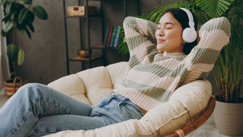 A woman relaxing with headphones on. 