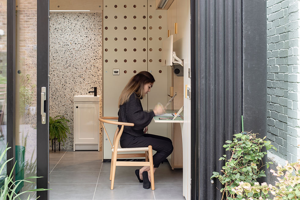 Compact home office pod in London with pegboard storage and desk.