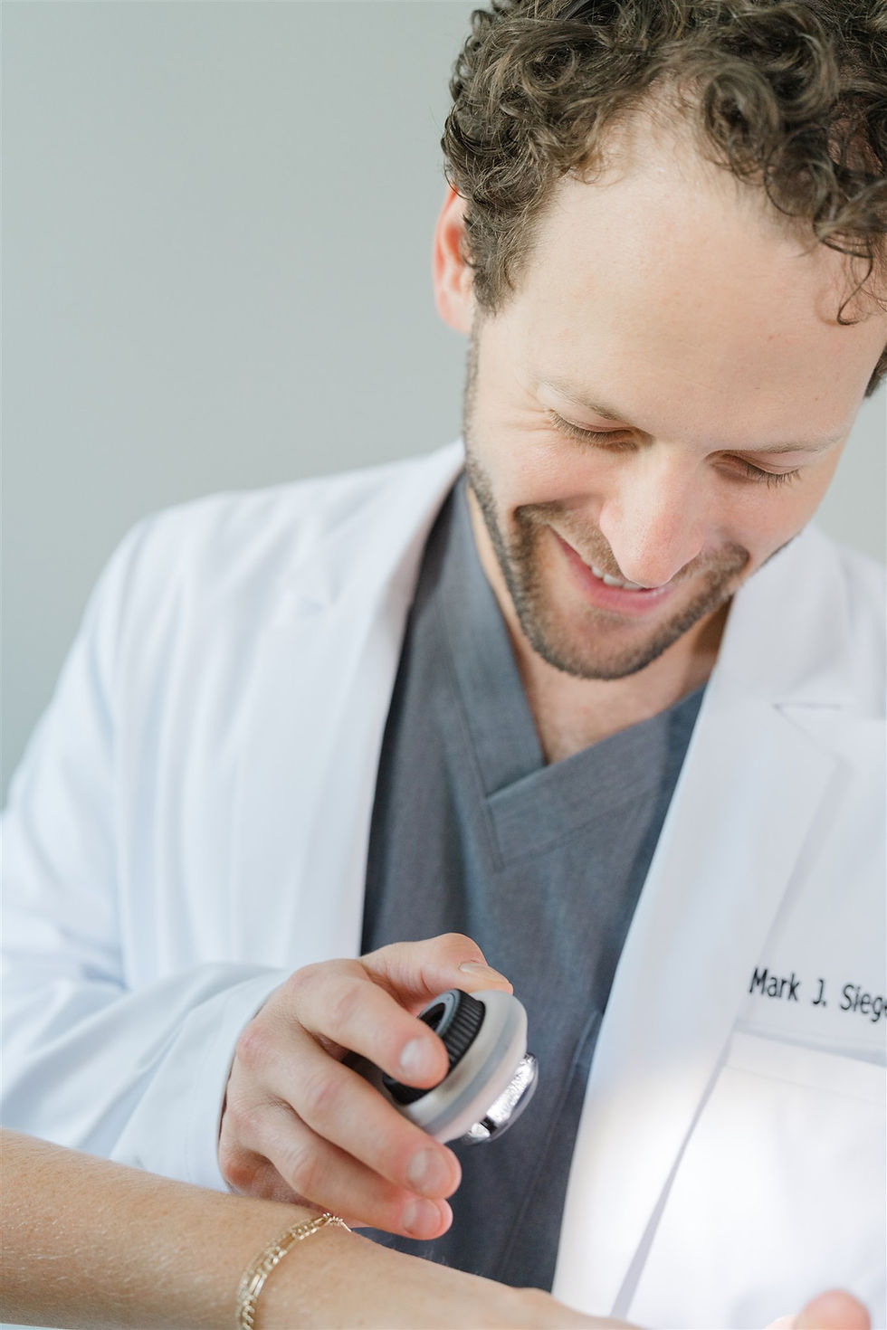 Dr. Mark Siegel, dermatologist, examining a patient