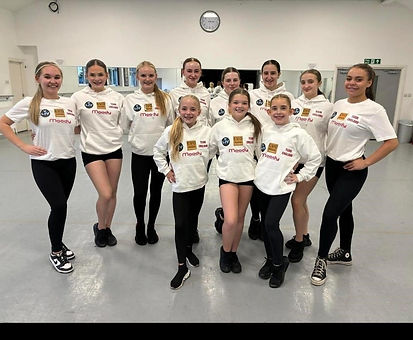 Group of young girls from dancing group with sponsorship hoodies