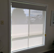 White roller blind filtering light through a window