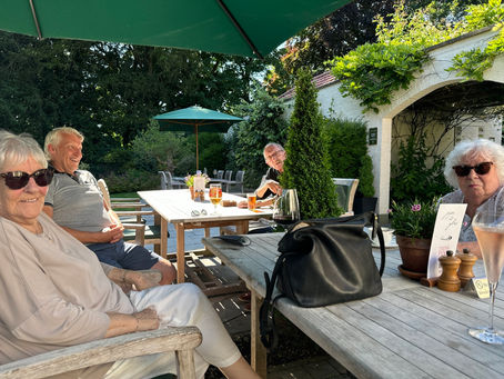 A family lunch with elderly people eating in a sunny pub garden