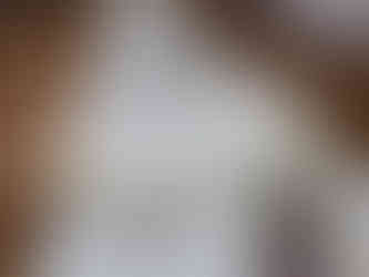 A close-up of the wedding reception table setup featuring soft green napkins, simple white plates, and a “Table 21” card in elegant script, surrounded by delicate floral arrangements in glass bud vases.