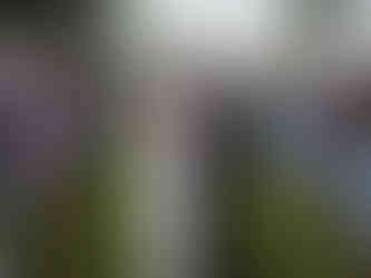 Nancy and Ammar walk back down the aisle arm in arm, smiling at each other as guests cheer and applaud around them. The joyful moment marks the end of their outdoor ceremony at Olin Park, surrounded by family, friends, and floral-lined rows of white chairs.