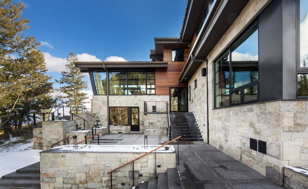 Modern mountain home exterior, stone and wood design