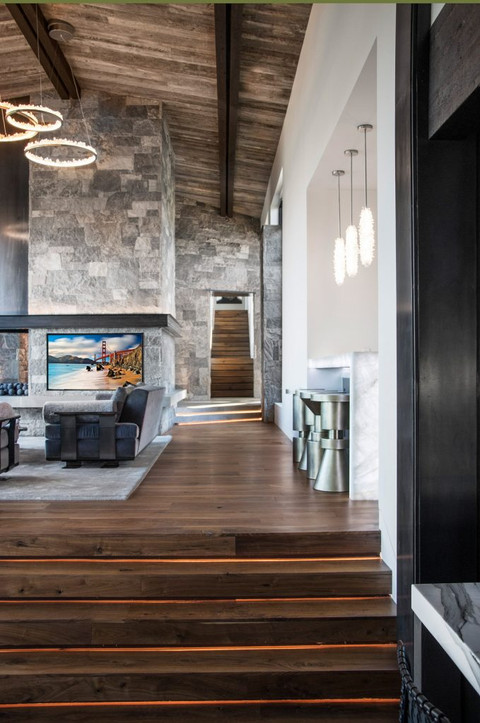 Modern home interior with wooden stairs and stone wall