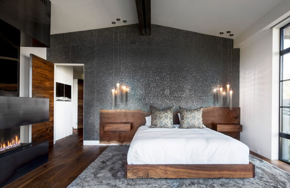 Modern bedroom with dark walls, walnut bed, and wall sconces