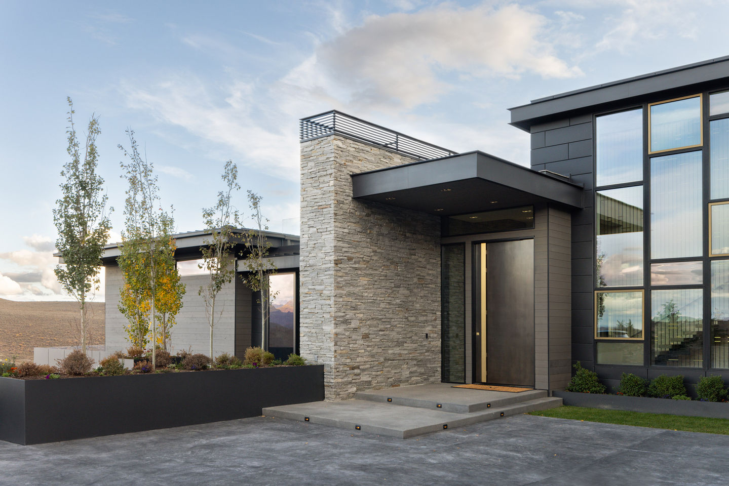 Modern home exterior, stone facade, glass windows