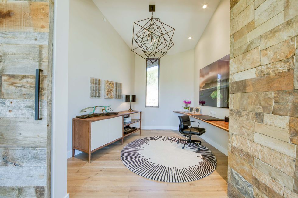 Modern home office with desk, chair, and geometric light fixture
