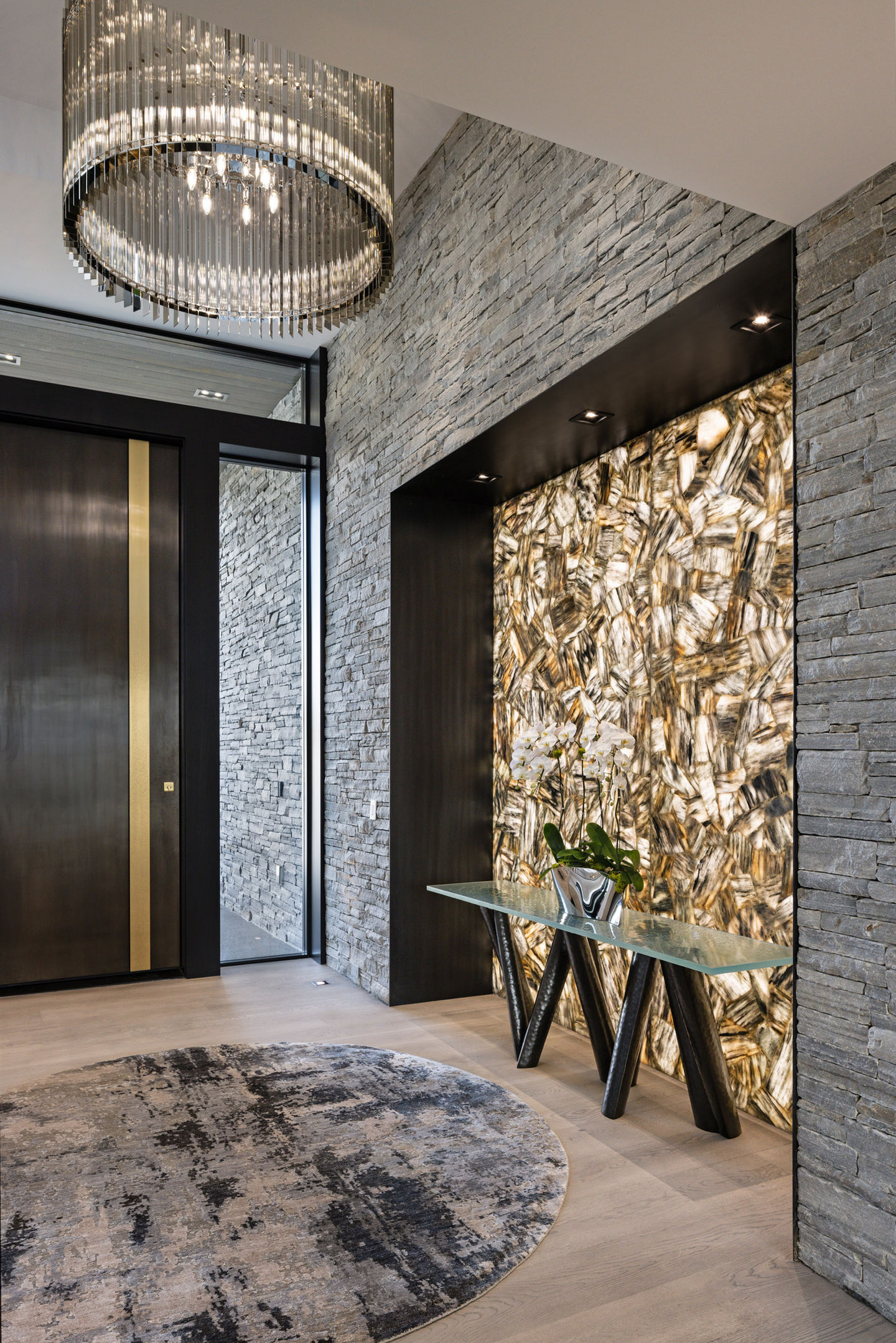 Modern entryway with stone wall, console table, and rug