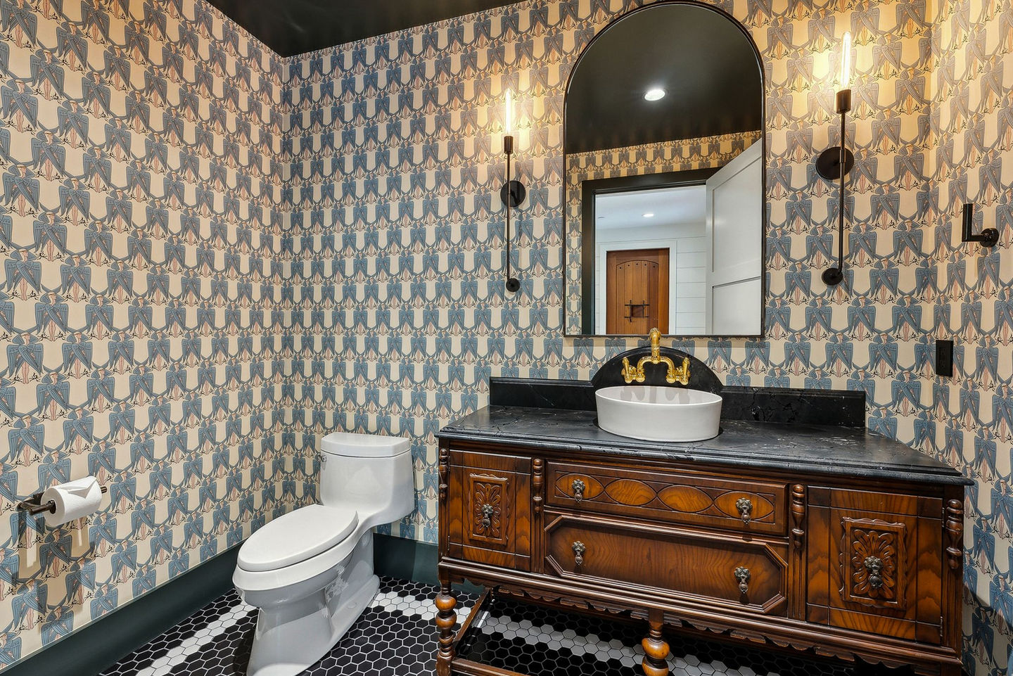 Elegant powder room with patterned wallpaper, antique vanity