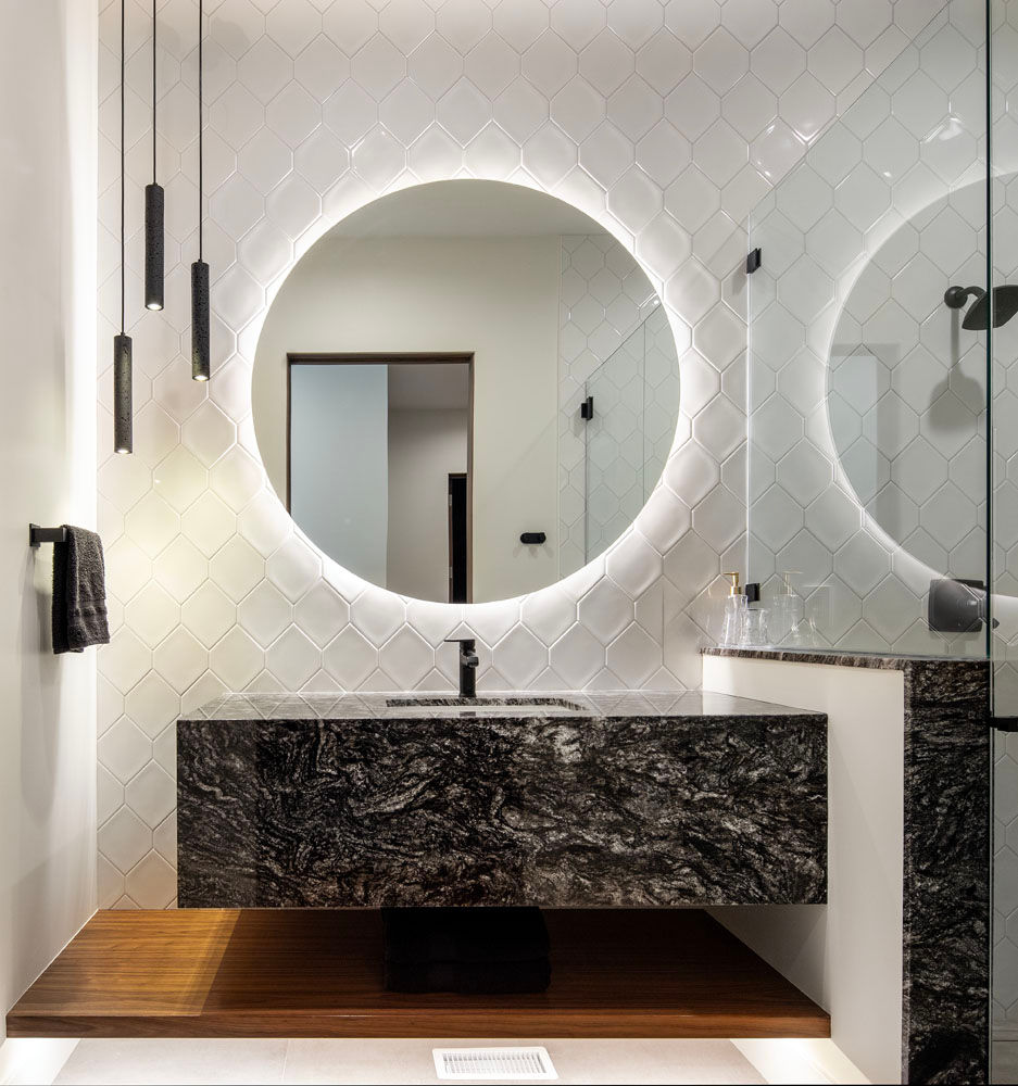 Modern bathroom with illuminated round mirror