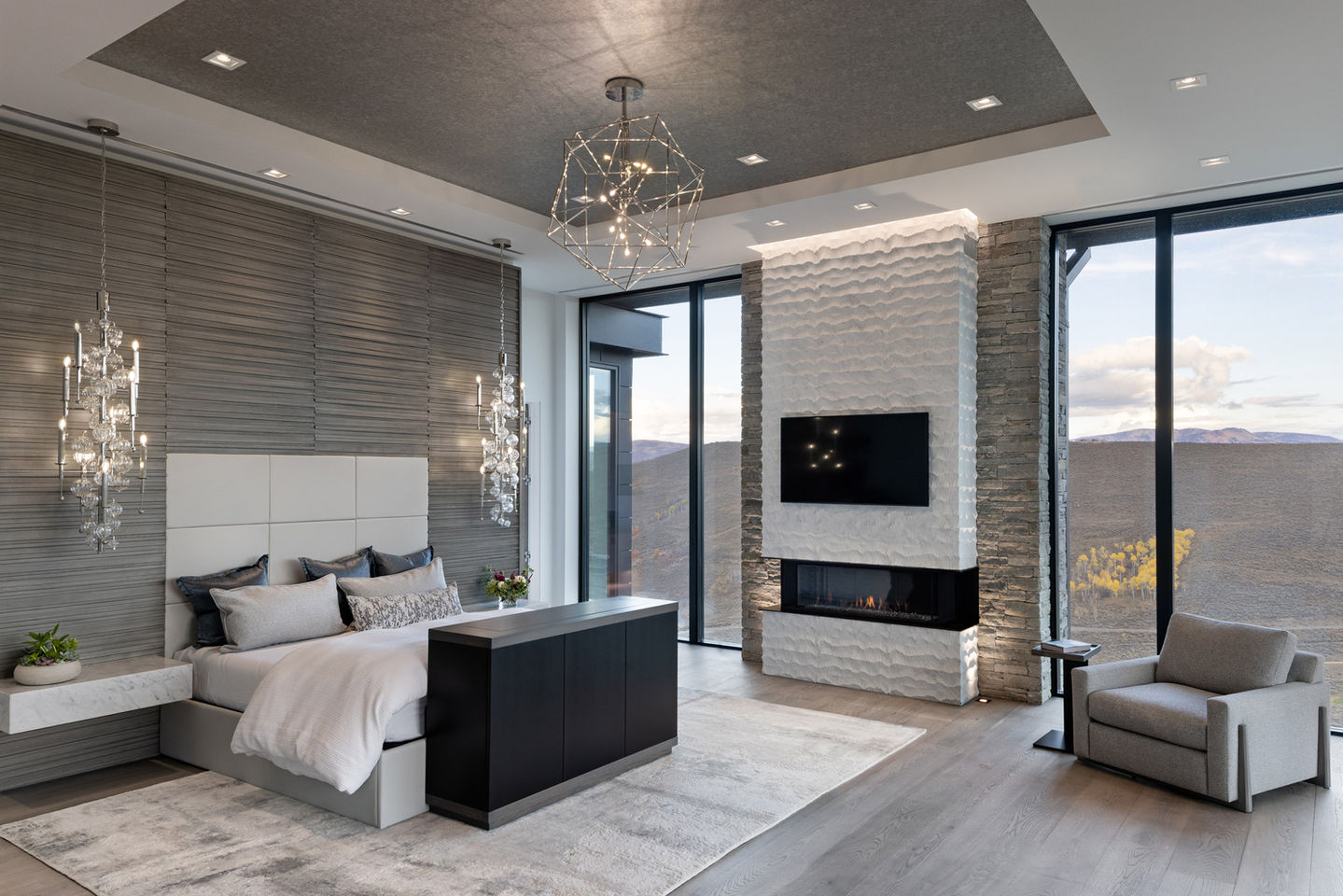 Modern bedroom suite with fireplace and mountain view