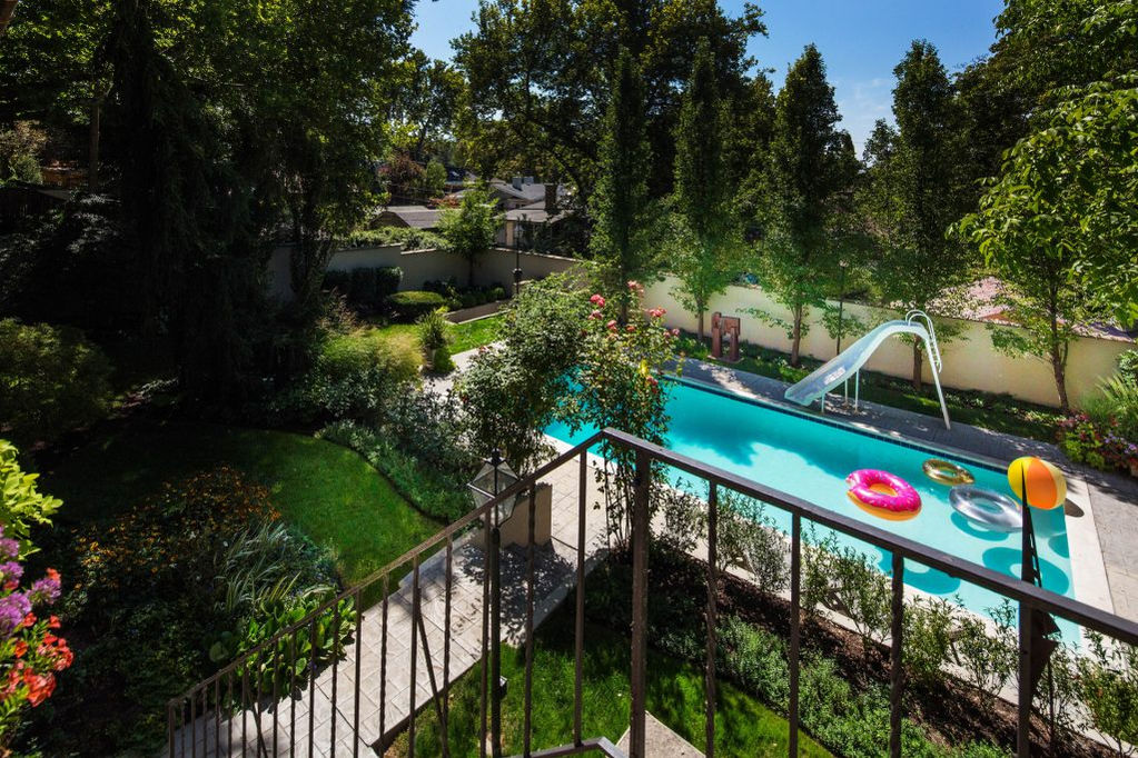 Elevated view of a backyard pool, lush landscaping