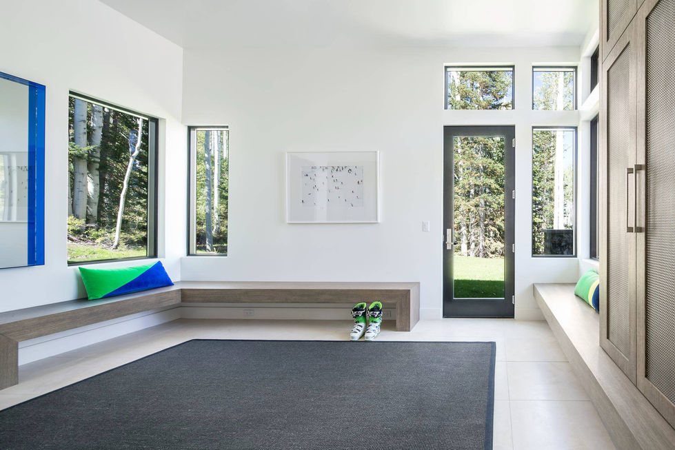 Modern entryway with bench, skis, and large windows