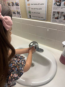 Preschool girl washing her hands