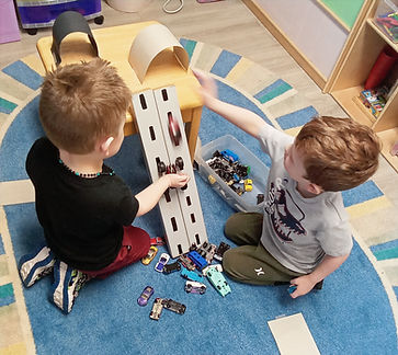 Preschool boys building ramps for small cars