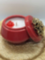 a candle in a red jar