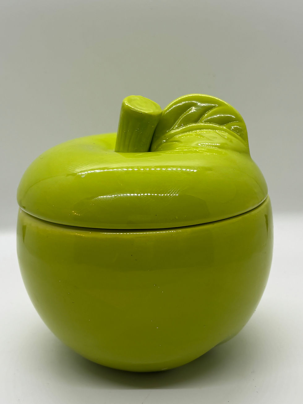 a candle in a green jar