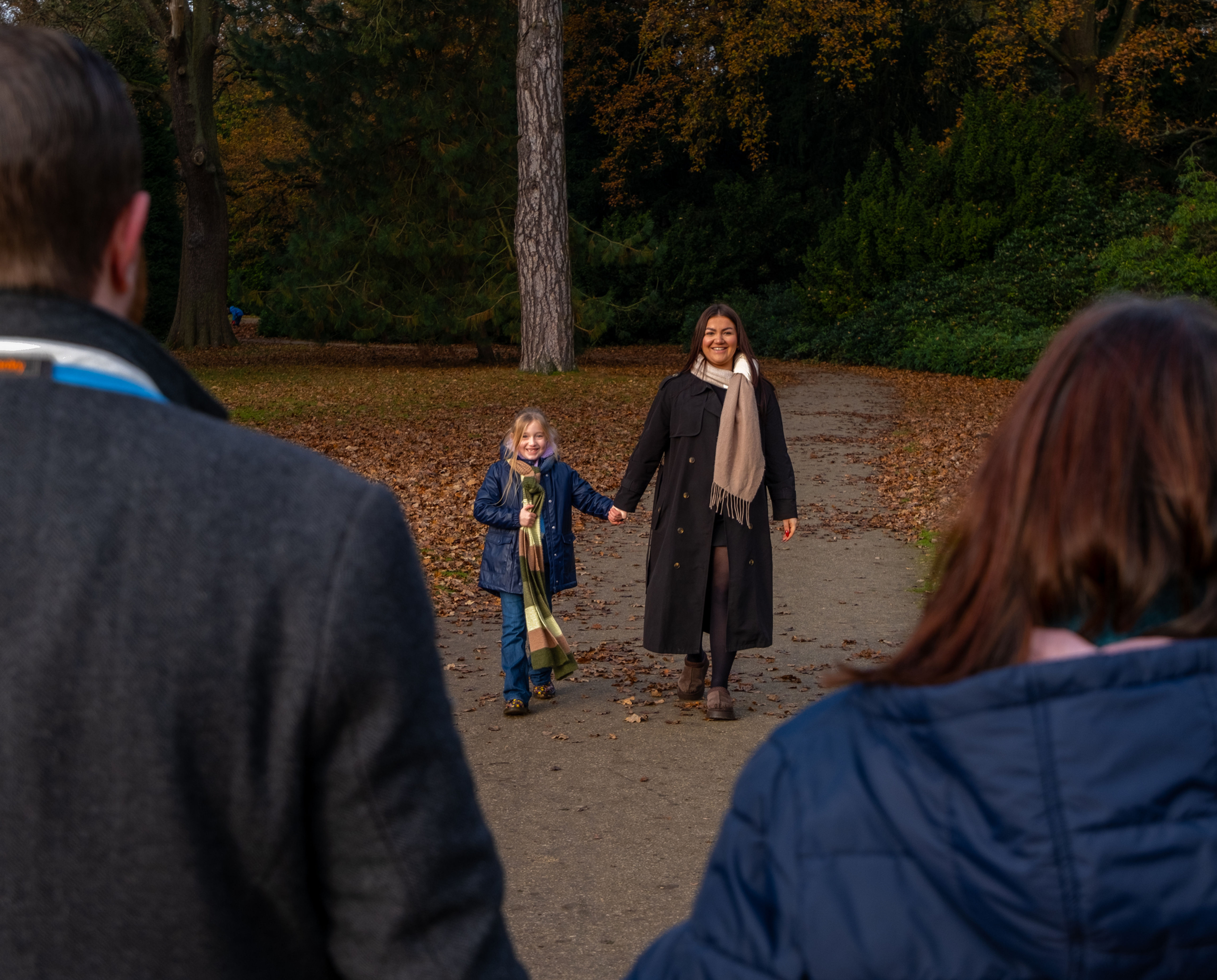 2 sisters walking happily towards their parents