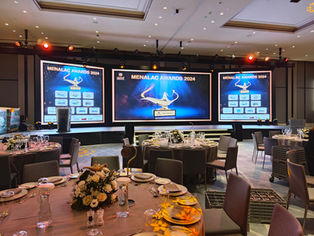 Indoor award ceremony setup with decorative lighting and audience seating.