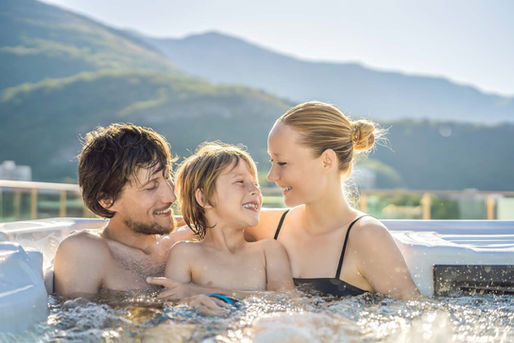 Eine junge Familie mit Kind hat gemeinsam Spaß im Whirlpool