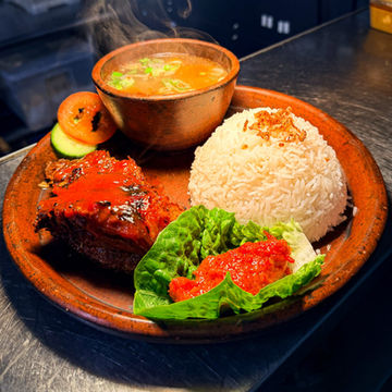 Slow-cooked Indonesian beef ribs (Nasi Iga Bakar) served with steamed jasmine rice and sambal at Bali Satay House in High Barnet, London.