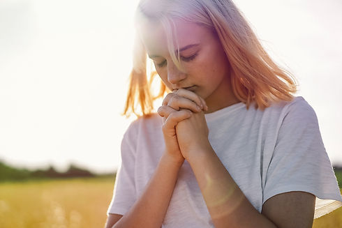 girl-closed-her-eyes-praying-in-a-field-