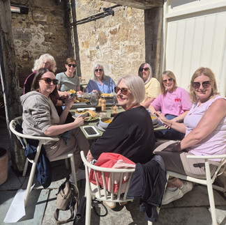 Women enjoying brunch at Bertram’s café in Northumberland, cosy interiors, artisan coffee and homemade cakes in a popular independent café setting.