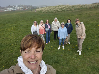 Women exploring Amble Harbour, Northumberland seaside town, scenic coastal walk, independent shops and waterfront views in “The Friendliest Port