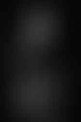 Monochrome image featuring a stylish woman posing confidently in modern and elegant clothing.