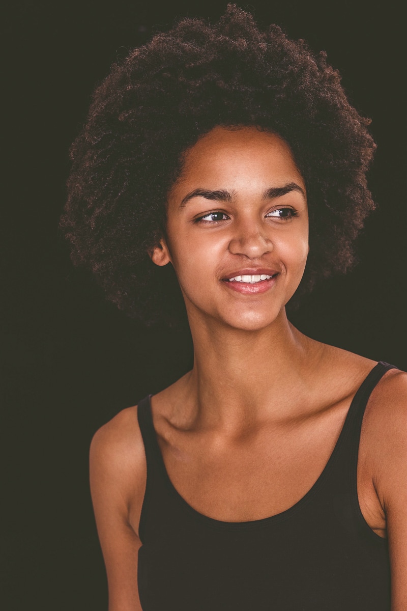 Portrait of a Smiling Woman in Front of a Black Studio Background